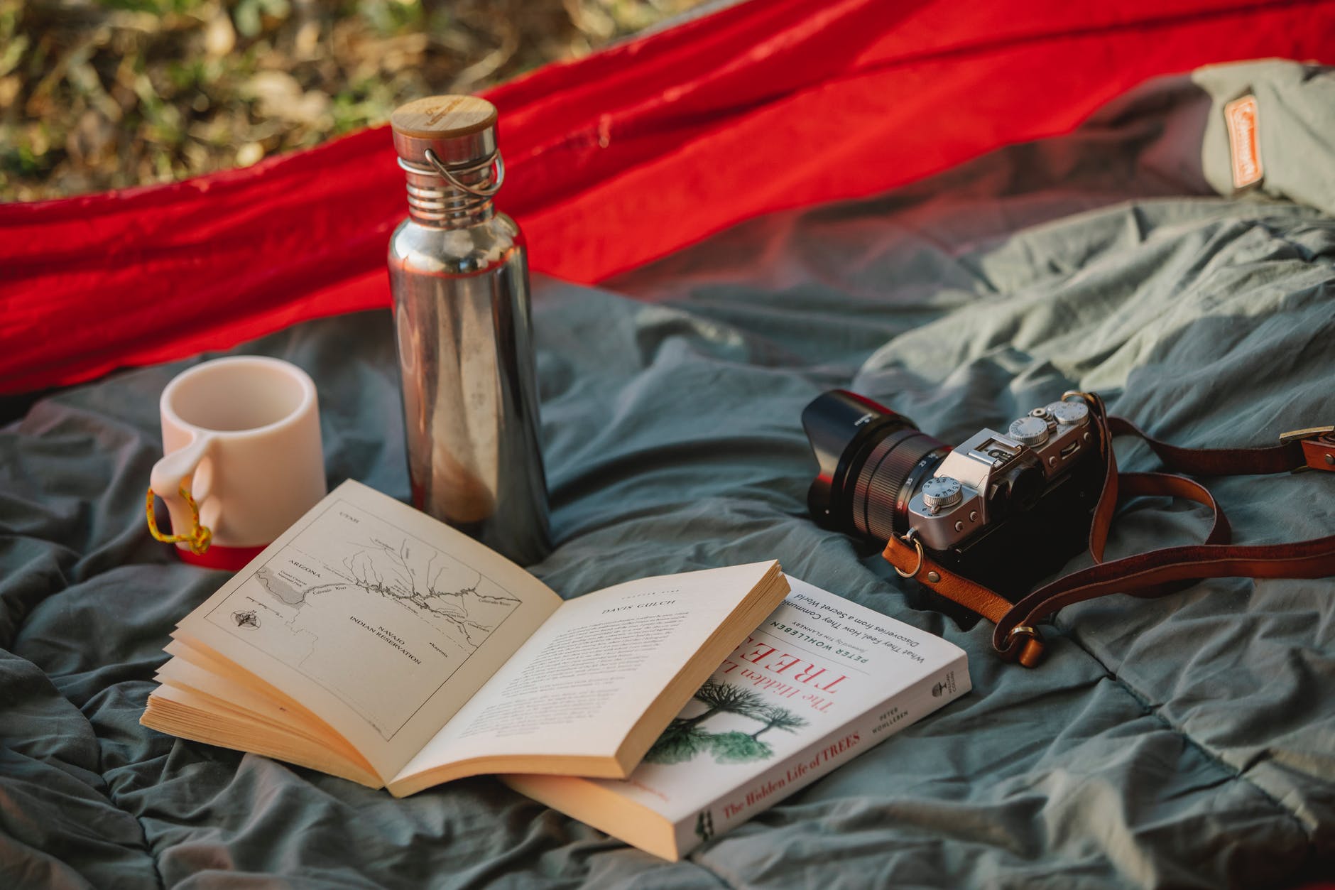 thermos books and photo camera on camp tent